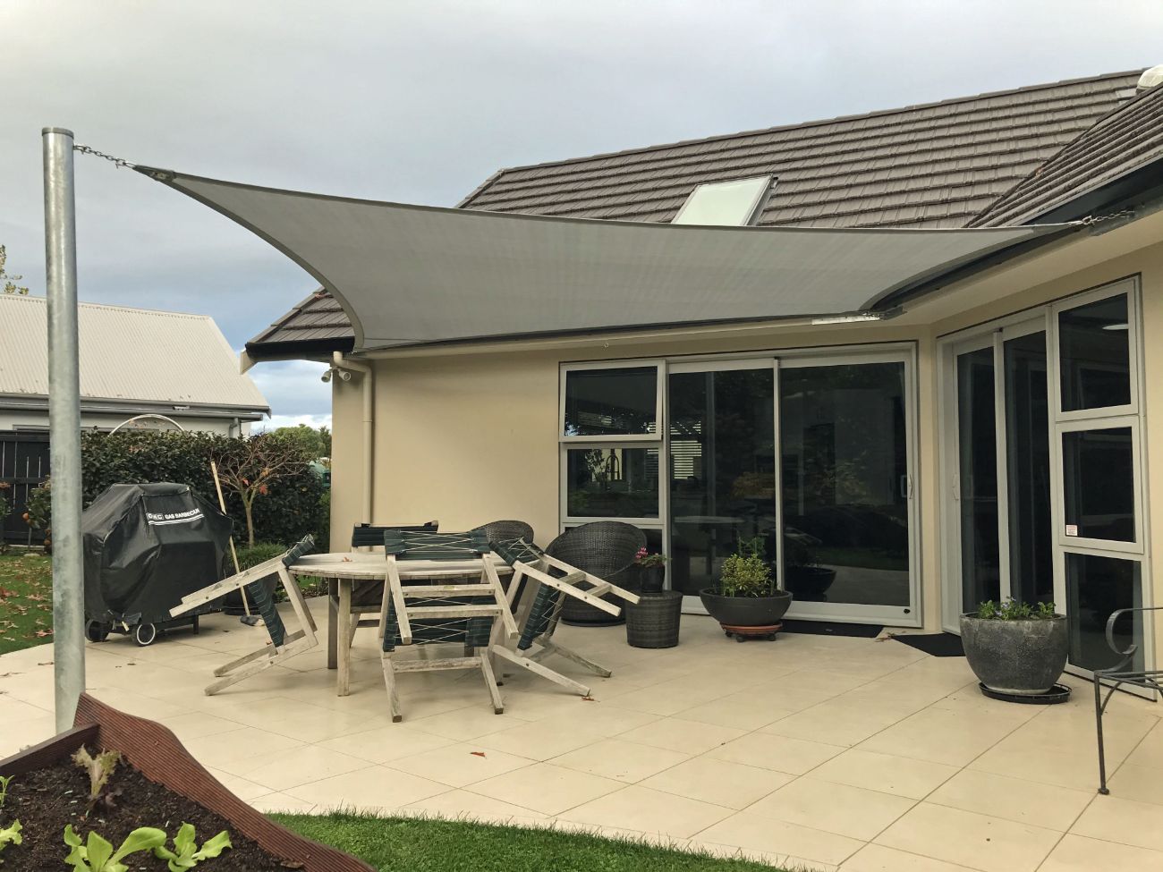 shade sail over house patio showing steel shade sail pole